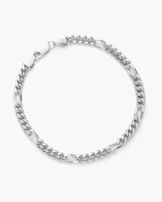 A classic Figaro chain features two or three flat links followed by one larger, elongated link. Our customized, silver Figaro chains are crafted in Italy using our best-selling Cuban links spaced two links further than a typical Figaro chain, for a unique twist. Collect our new 5mm Figaro bracelet in silver for a unique, dynamic look. Modern Link Bracelets With Figaro Chain, Modern Figaro Chain Bracelet, Silver Figaro Chain Link Bracelet, Minimalist Silver Figaro Chain Bracelet, Minimalist Silver Bracelet With Figaro Chain, Metal Figaro Chain Link Bracelet, Silver Bracelets With Rectangular Curb Chain Links, Modern Silver Bracelet With Figaro Chain, Silver Bracelet With Figaro Chain And Oval Link