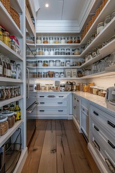 an open pantry with lots of shelves and jars on the walls, along with wooden floors