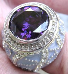 Item: Ladies AMETHYST & Cubic Zirconia (CZ) Designer Ring Composition: Lavender Enamel-Coated 925 Sterling Silver Main Gemstone: Amethyst measuring 13 mm in diameter & approx. 5.64 carats Accent Stones: Small, Round CZs in full design of ring Weight of Ring: 18.4 grams (.655 ounce) Ring Size: 7 Condition: Pristine, like new Shipping: Free within US & its Territories. A fee applies elsewhere. NOTE: Import duties, custom fees & taxes are not included in the item price or shipping f Luxury Lavender Jewelry As A Gift, Luxury Lavender Amethyst Ring For Gift, Luxury Lavender Amethyst Ring Gift, Purple Amethyst Ring With Diamond Accents For Gift, Purple Jewelry With Sparkling Stones For Anniversary, Formal Lavender Amethyst Ring With Cubic Zirconia, Ring Composition, Magical Jewelry, Multi Stone Ring