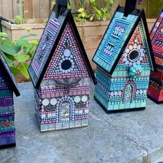 four colorful birdhouses are sitting on the cement