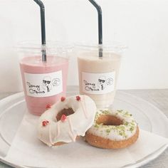 three donuts and two drinks on a plate