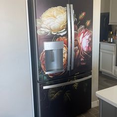 a black refrigerator with flowers painted on it