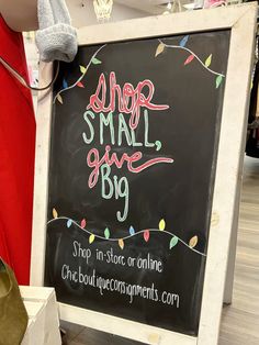 a sign that says shop small, give big on the side of a store's blackboard