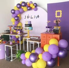 a birthday party with purple and yellow balloons