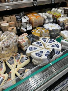 cheeses and other items are on display in a grocery store