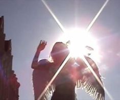 a person standing in the sun with their arms up