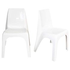 two white plastic chairs sitting next to each other