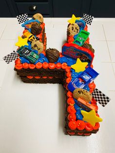 a cake shaped like the letter h with cars and stars on it sitting on a counter