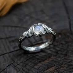 a close up of a ring on a piece of wood with a stone in the middle