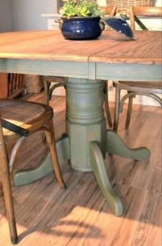 a wooden table with two chairs and a potted plant sitting on top of it