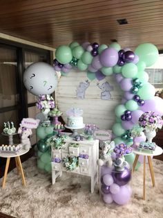 a table topped with lots of balloons and cake