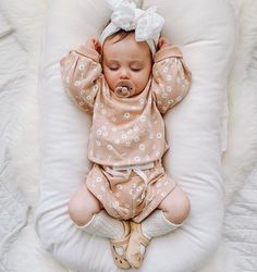 a baby is sleeping on a pillow with a pacifier in it's mouth