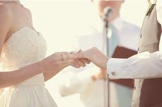 the bride and groom hold hands during their wedding ceremony in front of an outdoor microphone