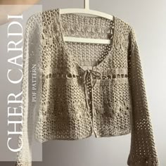 a crocheted cardigan hanging on a clothes hanger