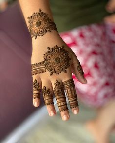 a woman's hand with henna tattoos on it