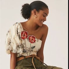 This Touch Of Especia Anthropologie Embroidered One Shoulder Crop Top In Size Small Is A Must-Have For Any Fashion-Forward Woman. The Cream-Colored Blouse Features A Beautiful Floral Pattern And Is Made Of A Soft Cotton Blend Material That Feels Amazing Against The Skin. The Short Balloon Sleeves And One-Shoulder Neckline Add A Touch Of Elegance, Making It Perfect For Both Casual And Formal Occasions. The Blouse Is Hand Wash Only And Has Embroidered Accents That Add A Unique Touch To The Overall Mexican Shirt Outfit, Summer Tops Women, Mexican Top, Embroidered Tops, One Shoulder Crop Top, Mexican Shirts, Womens Tops Summer, Anthropologie Top, Shoulder Crop Top