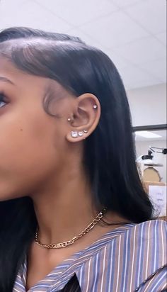 a close up of a person with ear piercings on their ears and wearing a striped shirt