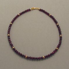 This chain of garnet beads looks both classic and noble due to the rich dark red color and size of the gemstones. When the necklace is in motion, the beveled edges of the garnet gemstones appear to sparkle. Individual gold-plated silver discs nestled between the garnet beads give the necklace a relaxed appearance and allow the red color of the stones glow warmly. The matching bracelet and earrings can also be purchased here at our jewellery factory's online shop. . Dimensions: Diameter of the st Mens Garnet Necklace, Garnet Bead Necklace, Red Garnet Necklace, Dark Red Color, Red Beaded Necklaces, Bezel Necklace, Beads Bracelet Design, Garnet Necklace, Garnet Jewelry