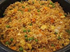 a pan filled with rice, peas and carrots