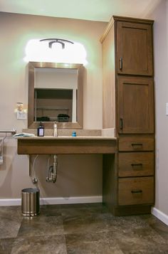 a bathroom with a sink, mirror and cabinet next to the toilet paper dispenser