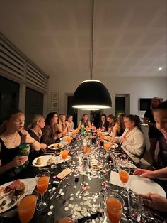 a group of people sitting around a table with food and drinks in front of them