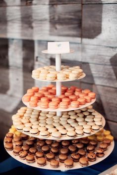 three tiered trays with different types of donuts on top of each other