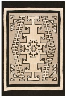 a black and white rug with an intricate design on the center, surrounded by smaller squares