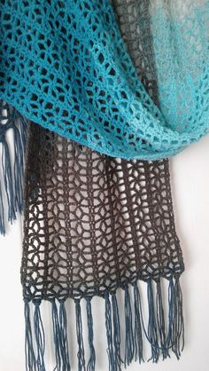 two scarves with tassels on top of each other, one blue and the other gray