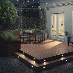 an outdoor deck with lights on it and some plants in the back ground next to it