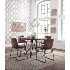 a dining table with four chairs and a vase on it in front of a window