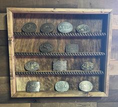 an old wooden display case with metal coins on the sides and roped edges, mounted on wood planks