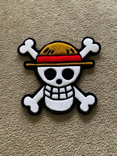 a patch with a skull wearing a hat and crossbones on it's side