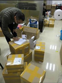 a man standing over boxes in a warehouse