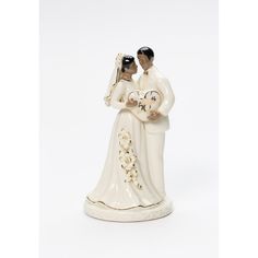 a ceramic figurine of a bride and groom holding a heart