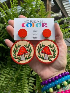 "These beautiful hand painted mushroom earrings are made from 1/8\" basswood and are truly one of a kind. Hand painted with a little tiny brush this statement piece is a must have. Dress them up or down they are always ready and will complement any outfit.  Want a different color? No problem, send me a message. If I can accommodate the custom color there will be no additional charge. My lightweight wood earrings are the perfect compliment to any outfit. All my wood earrings are made with Nicklel Painted Wood Earrings Ideas, Diy Painted Wood Earrings, Painted Wooden Earrings Handmade, Hand Painted Earrings Wood, Wooden Handpainted Earrings, Playful Hand-painted Dangle Earrings, Cottage Core Style, Ancient Egyptian Jewelry, Hand Painted Earrings