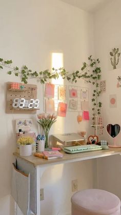 a white desk topped with a clock next to a plant filled wall mounted on the wall