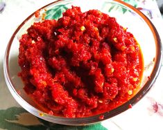 a bowl filled with red sauce on top of a table