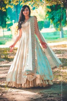 a woman in a white and blue dress is standing on the ground with her arms outstretched