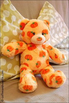 a teddy bear sitting on top of a bed next to pillows