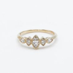 a gold ring with three pear shaped diamonds