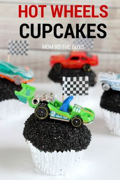 hot wheels cupcakes with black frosting and race cars on top, sitting on a white plate