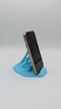 a cell phone sitting on top of a blue piece of plastic that is stuck in the ground