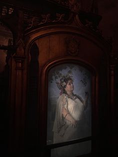 a woman with a crown on her head standing in front of a painting