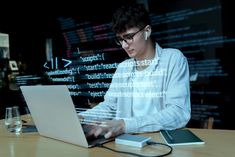 a man sitting at a table using a laptop computer