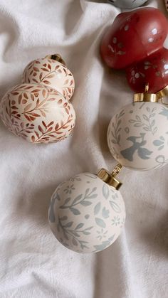 three ornaments are laying on a white sheet