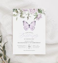 a purple butterfly birthday party with flowers and greenery on the side, in front of a white background