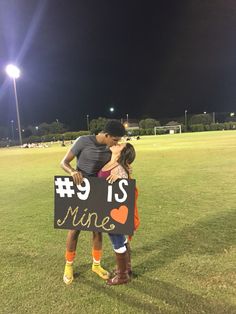 two people hugging each other while holding a sign