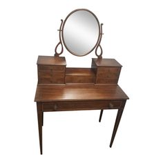 a wooden desk with a mirror on top of it and drawers underneath the table, against a white background