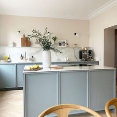 a kitchen with blue cabinets and white counter tops is seen in this image from the dining room