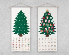 two calendars with christmas trees on them hanging from clothes pins and wooden pegs